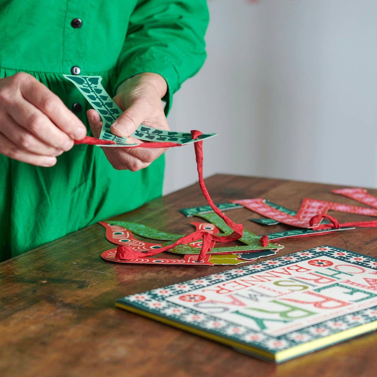 Cambridge Imprint Merry Christmas paper banner with red and green patterned letters and holly sprigs, view 2