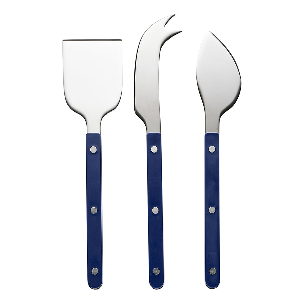 Three cheese knives with navy blue riveted handles: a cleaver, a fork tipped knife and a spreader