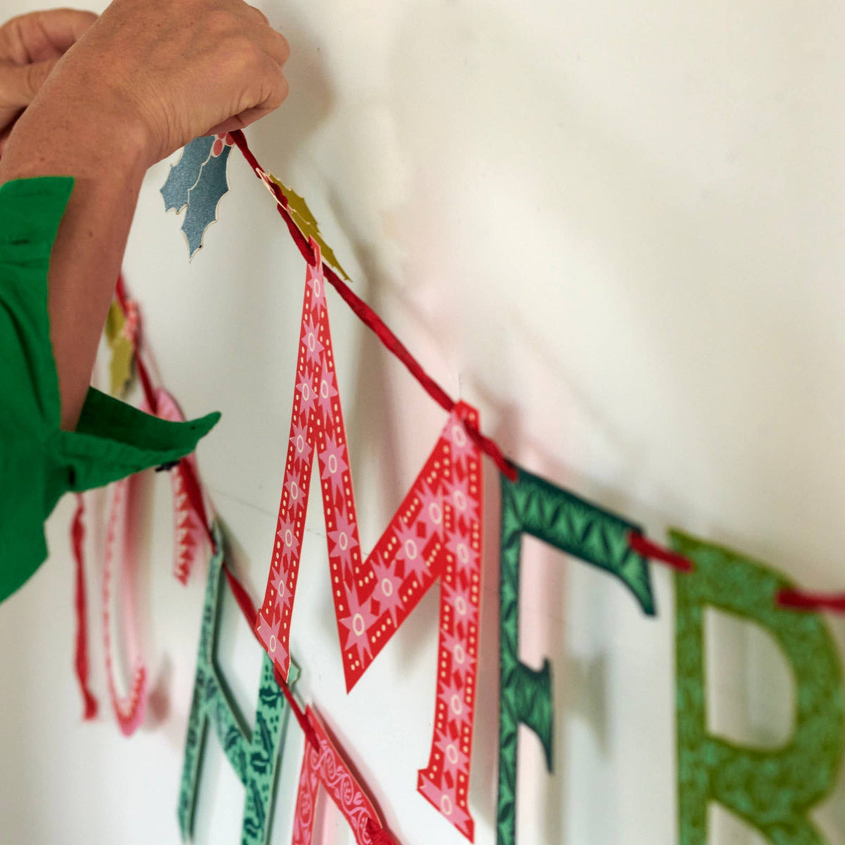 Cambridge Imprint Merry Christmas paper banner with red and green patterned letters and holly sprigs, view 5